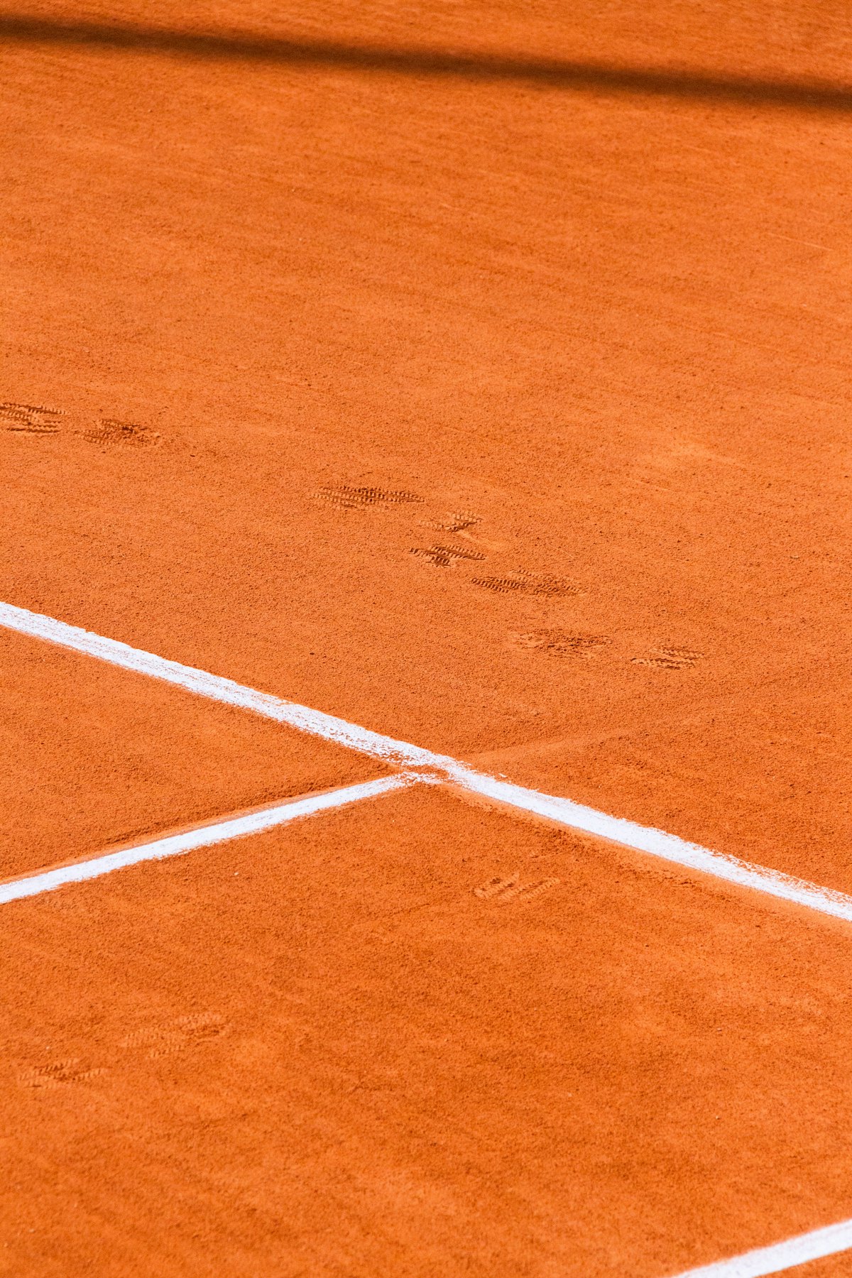 Linien und Spielspuren auf einem gepflegten Tennis-Sandplatz